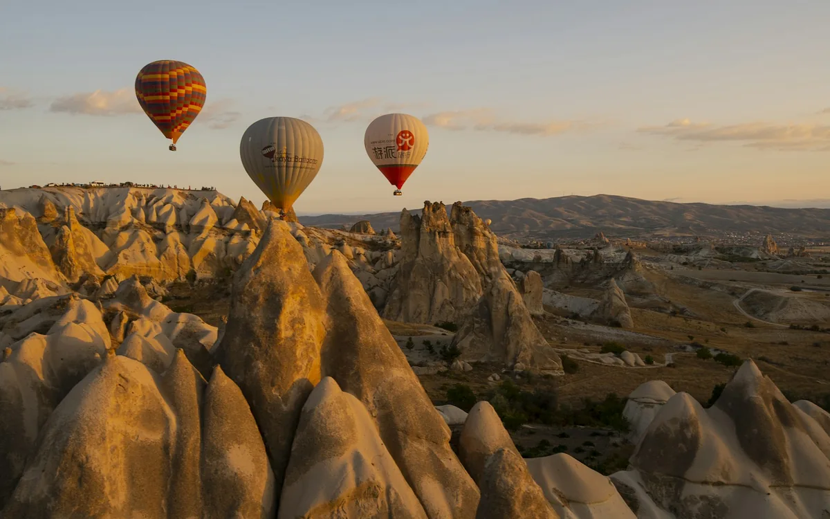 Hot air balloons above the rock formations of Cappadocia, Türkiye